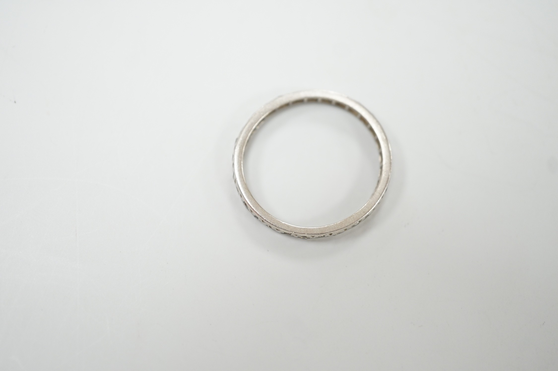 A white metal and diamond chip set full eternity ring, size K, gross weight 1.8 grams.